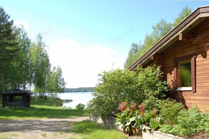 Niittylän hirsimökki rannan tuntumassa