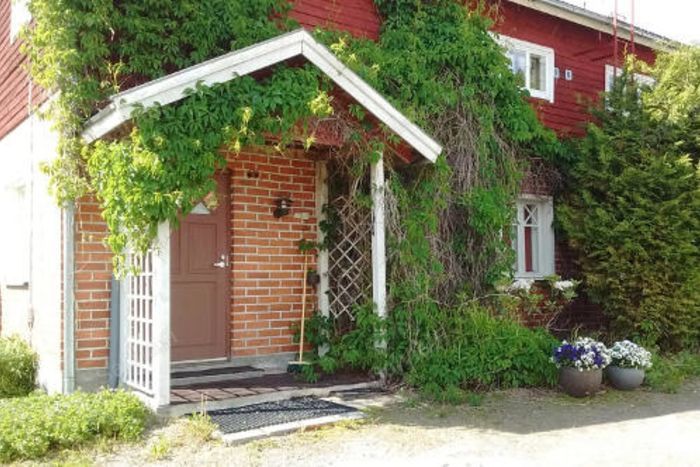 Punaisen tuvan loma-asunnon köynnösten peittämä kuisti